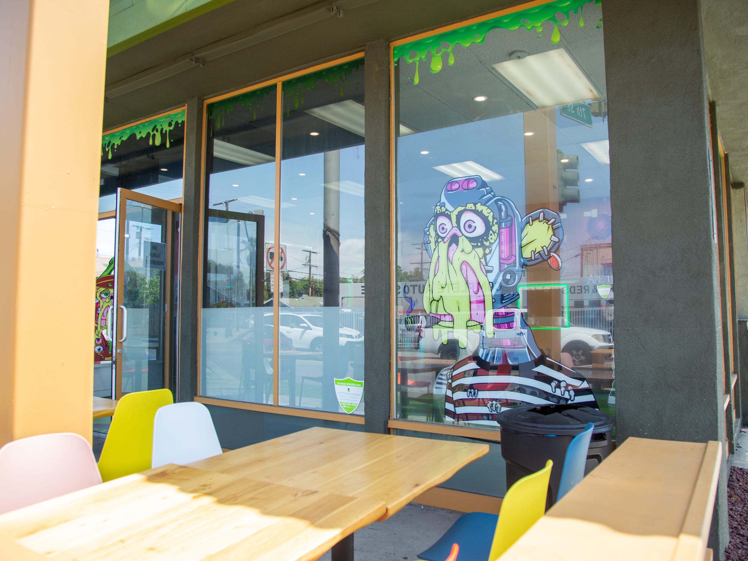 The exterior of the Bored and Hungry store with tables, chairs, a mutant ape decal.