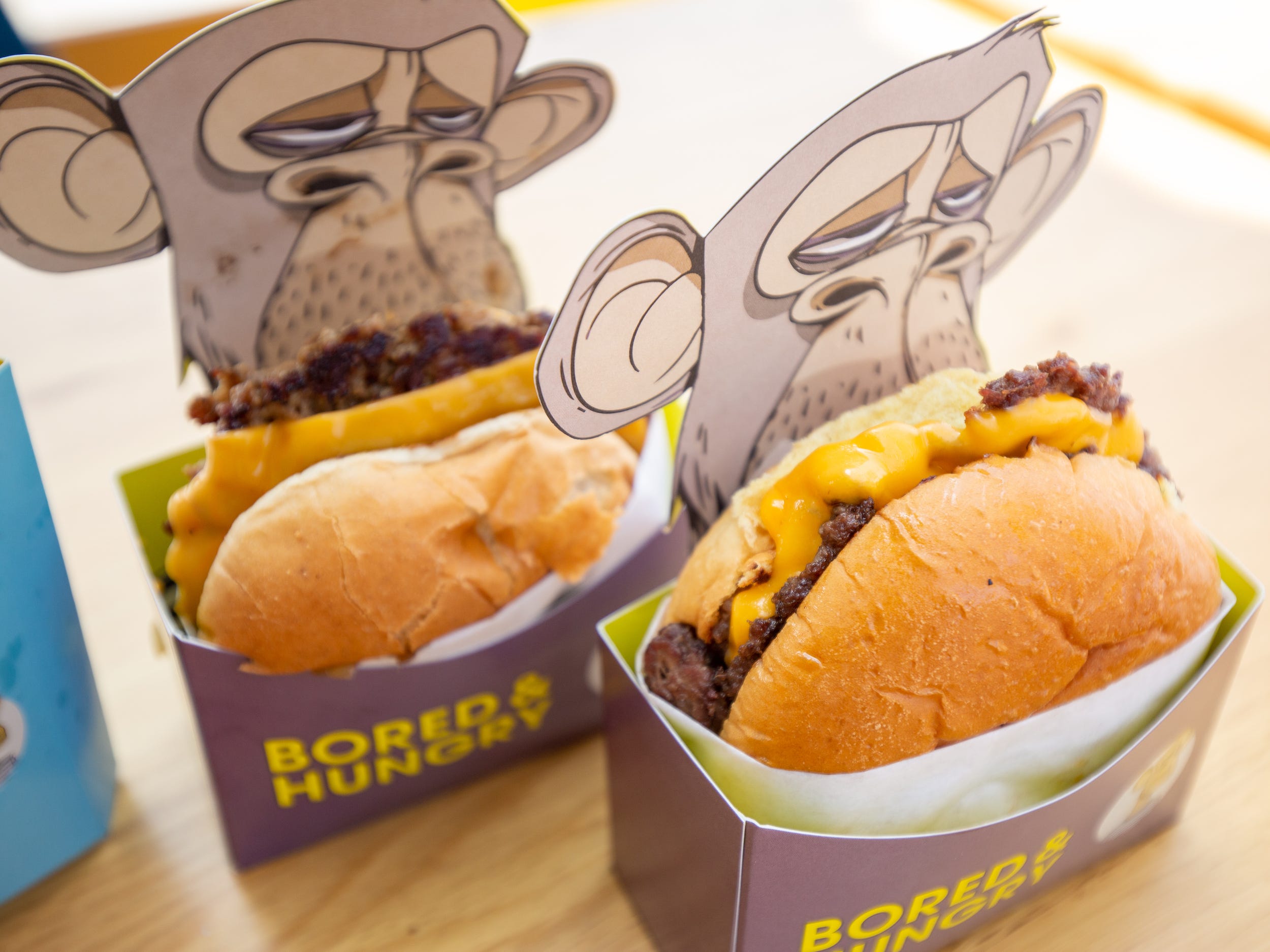 Two burgers in the ape branded Bored and Hungry packaging.