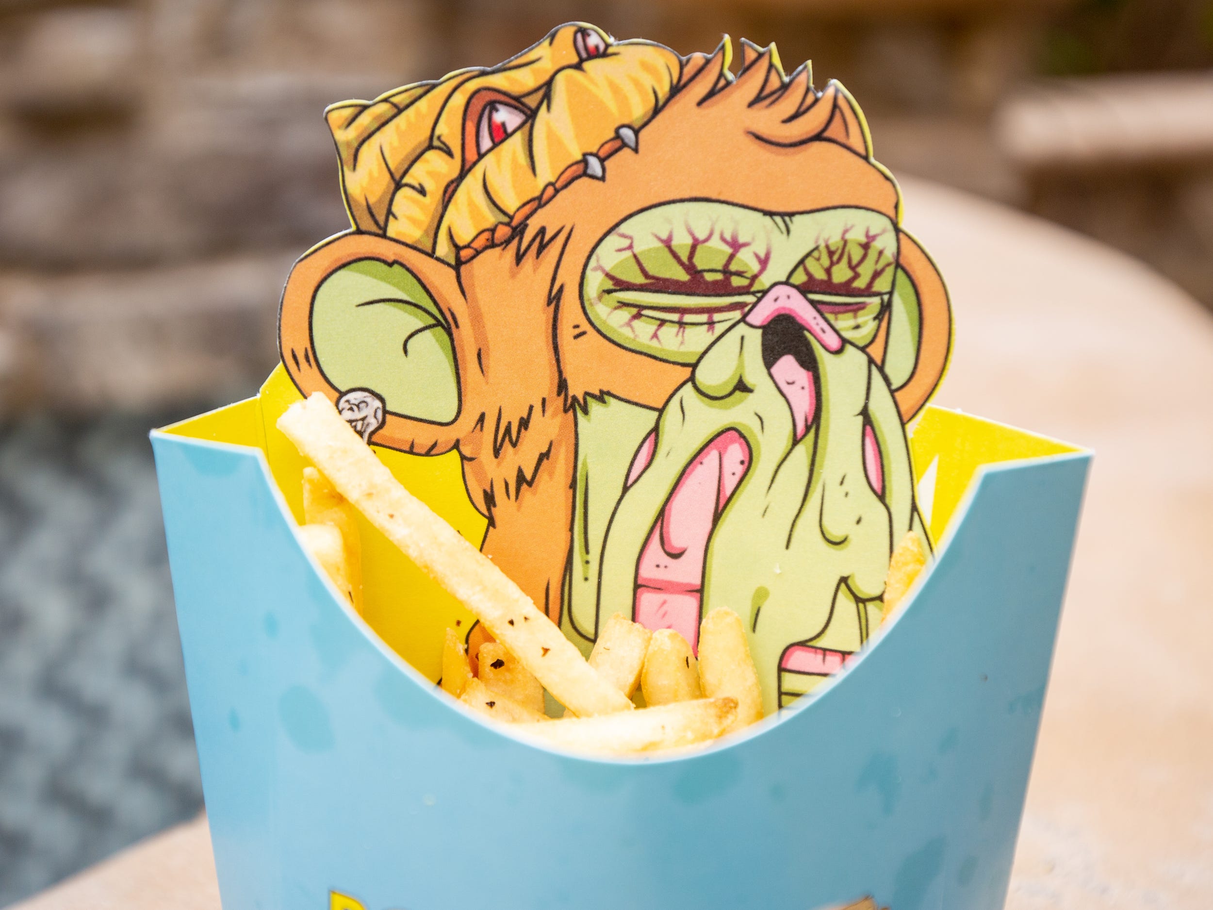 Fries inside of a Bored and Hungry container with an ape on the packaging.