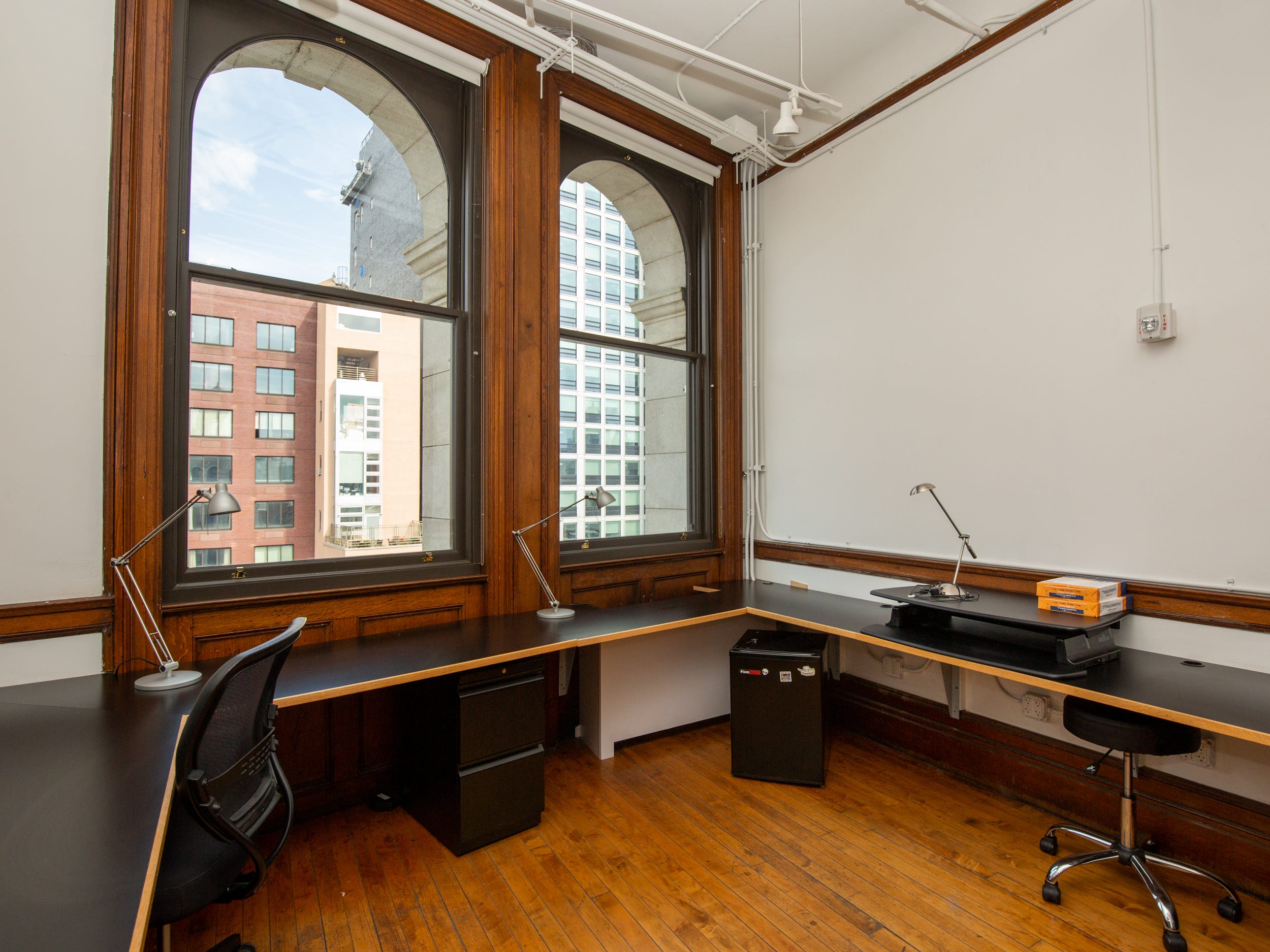 Long table, office chairs and large windows.