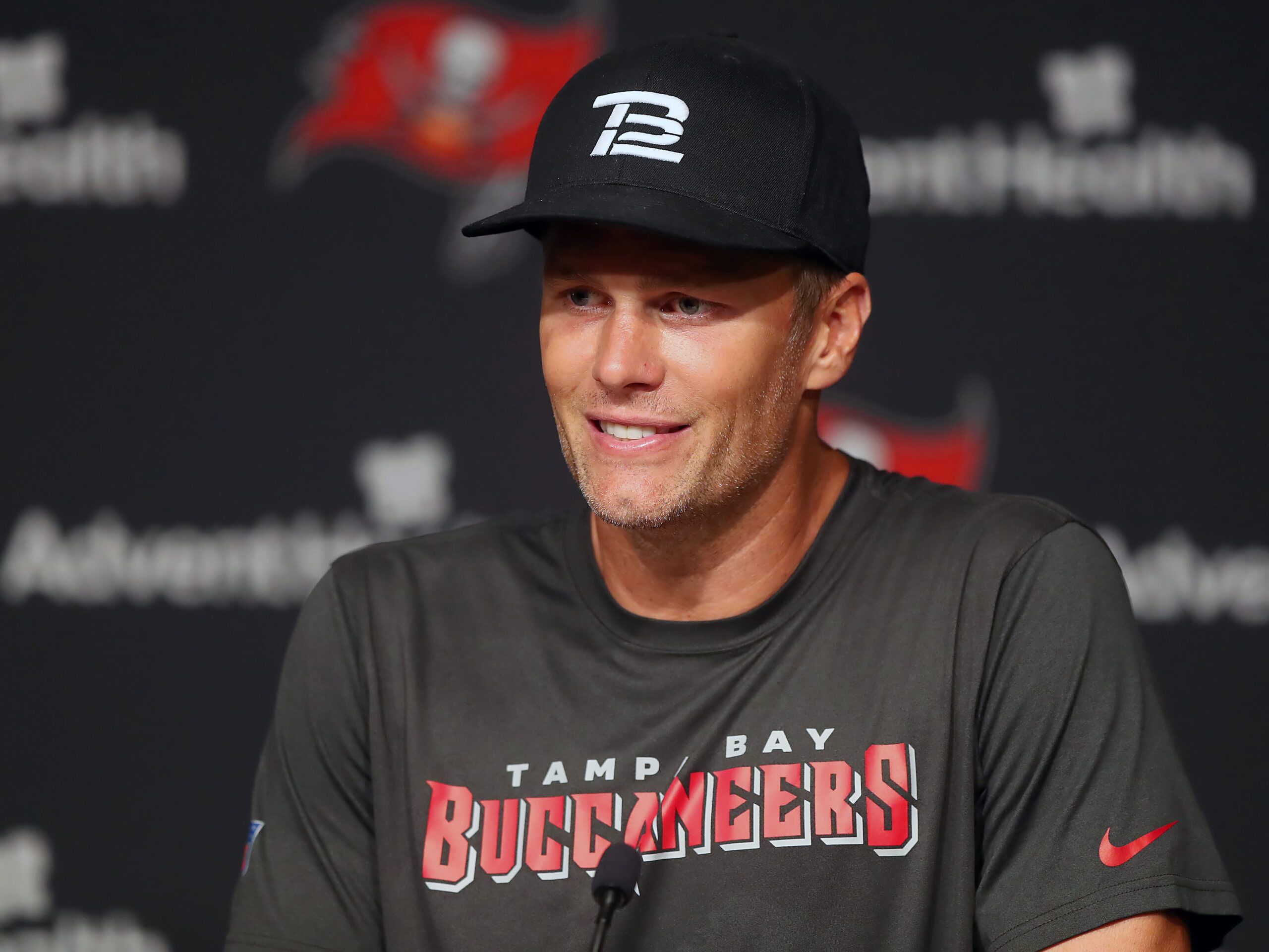 Tom Brady wears a black TB12 hat during a press conference.