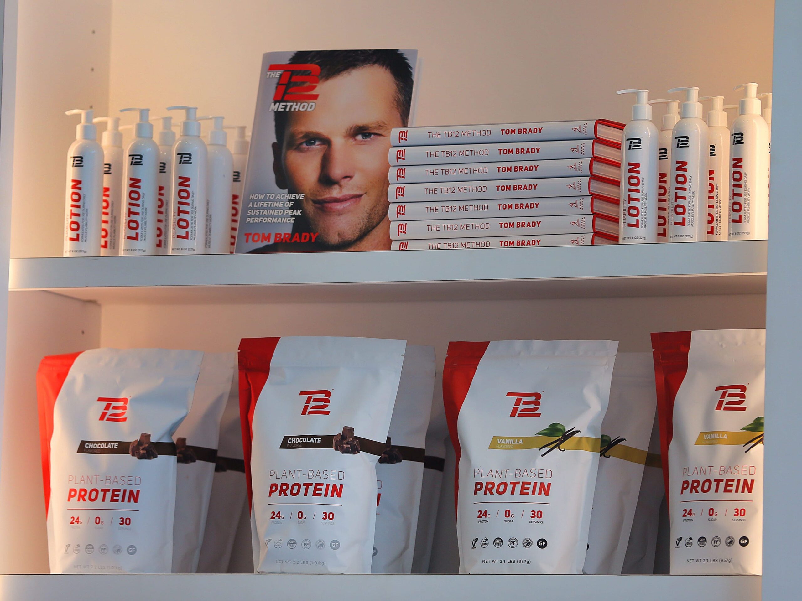 TB12 merchandise on a shelf accompanied by a photo of Tom Brady.
