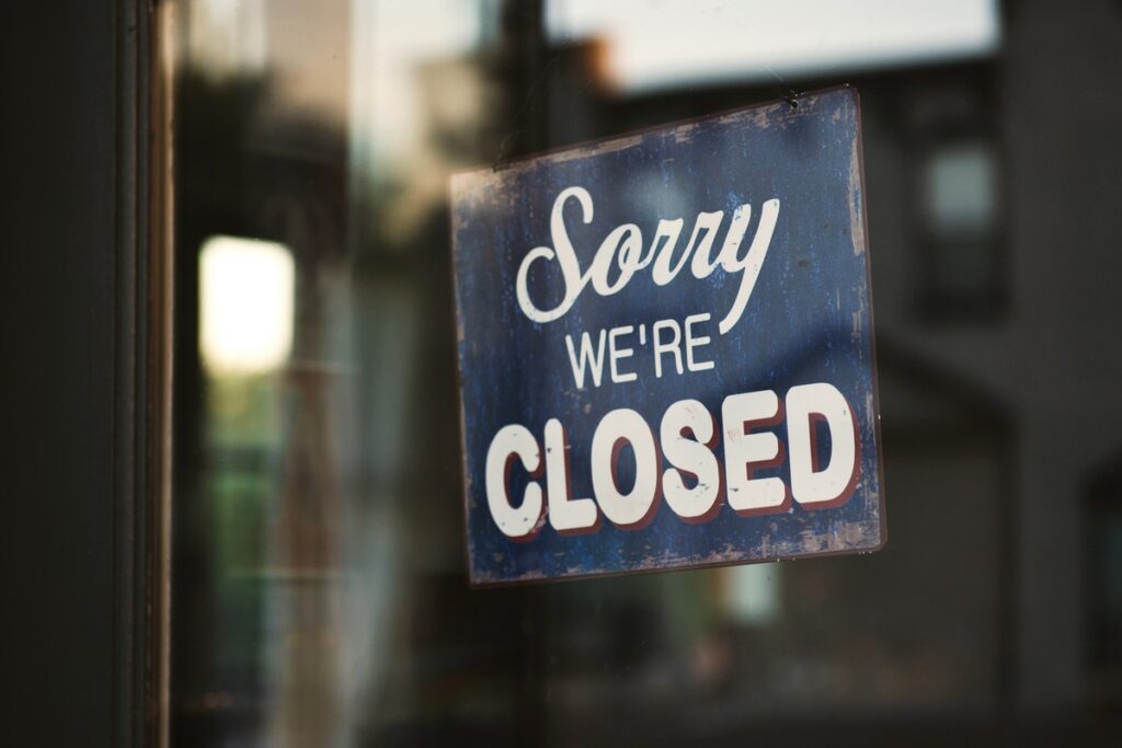 A closed sign displayed in store front.